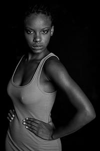 woman wearing tank top stands inside the dark room thumbnail