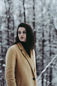 selective focus photography of woman near snow covered trees thumbnail