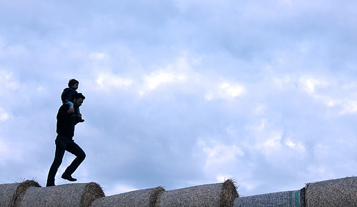 man walking with kid on shoulder during daytime thumbnail