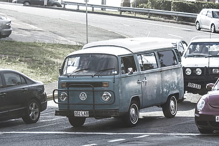 blue Volkswagen van surrounded by cars on road at daytime thumbnail