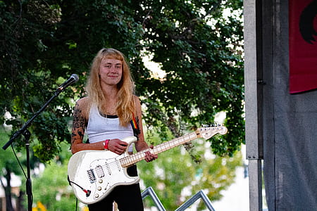 Woman Holding White Electric Guitar thumbnail