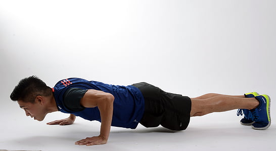 man doing push-up on white floor inside the building thumbnail