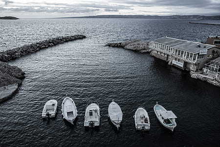 landscape photography of body of water with six boats thumbnail