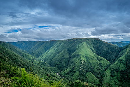 Landscape Photography of Green Mountains Under Cloudy Sky thumbnail