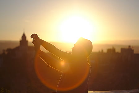 golden hour photography of man standing on top of a building thumbnail