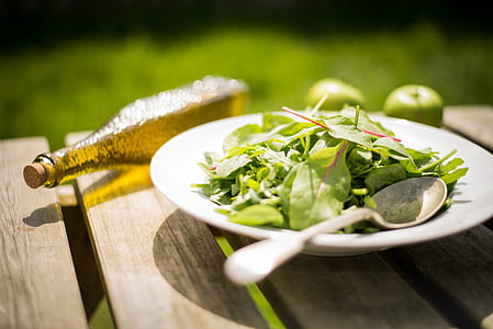 green leaves on white ceramic plate beside brown glass cork bottle thumbnail