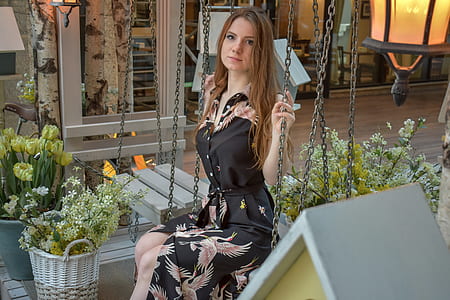 woman wearing black and pink dress sitting on swing thumbnail