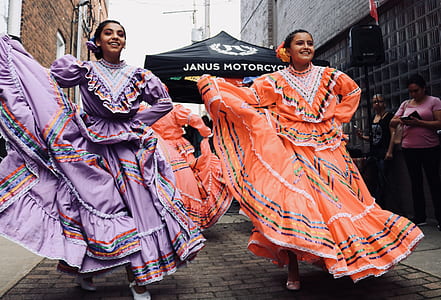 two women dancing on the street beside the building thumbnail