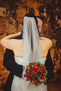 wedding couple kissing beside brown concrete wall thumbnail