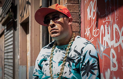Photo of Man Wearing Black and White Cannabis Print Top and Gold-colored Necklace thumbnail