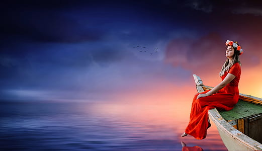 woman wearing red dress sitting on the boat surrounded by body of water thumbnail