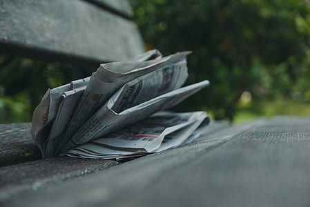 newspaper folded on wooden bench outdoor thumbnail