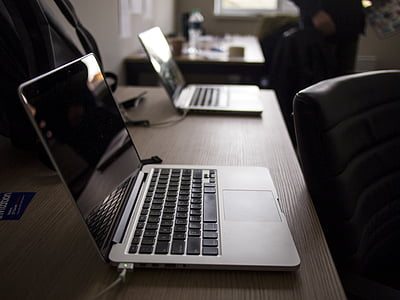 two gray laptop computers turned off on the table thumbnail