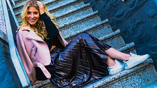 woman sitting down on staircase holding back hair thumbnail