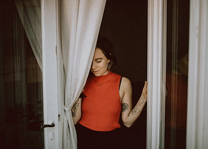 woman wearing knit shirt near window curtain thumbnail