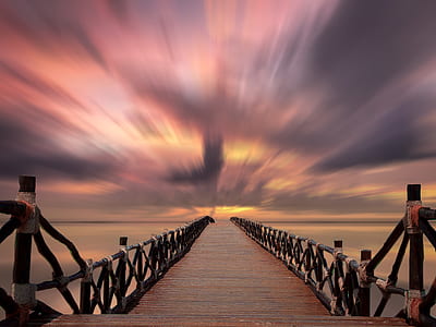 timelapse photo of wooden bridge during golden hour thumbnail