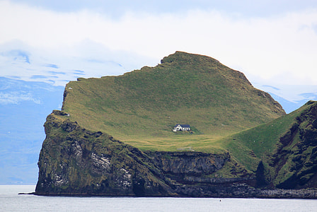 blue and white house on island under white sky thumbnail