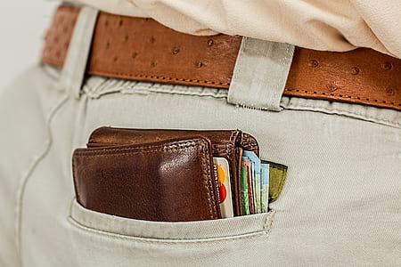 person wearing gray denim bottoms with brown leather wallet thumbnail