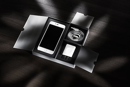 white smartphone with charger inside of box on floor thumbnail