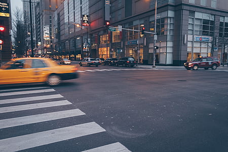 yellow car in motion crossing through pedestrian lane thumbnail