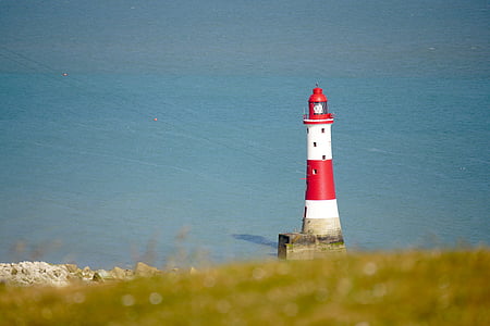 red and white lighthouse near body of water thumbnail