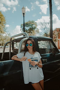 woman leaning on black single cab pickup truck while holding ice cream cone during daytime thumbnail