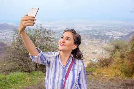 woman in blue and white striped button-up shirt during daytime thumbnail