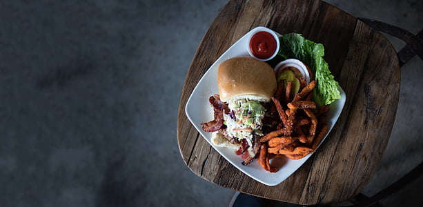 burger with hand and ketsup on plate thumbnail