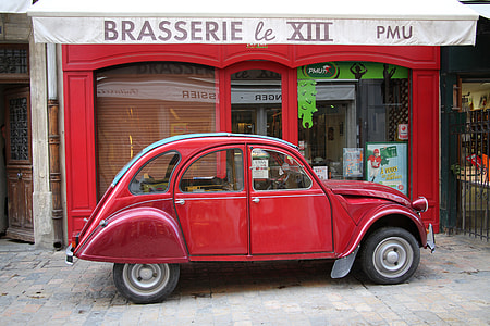 red beetle car parked near building thumbnail
