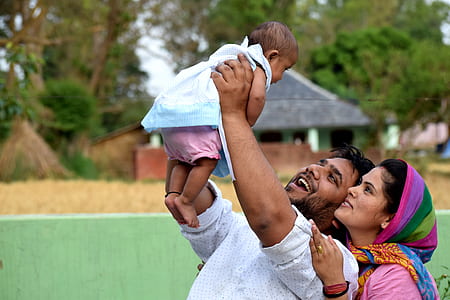 man holding white dressed baby thumbnail