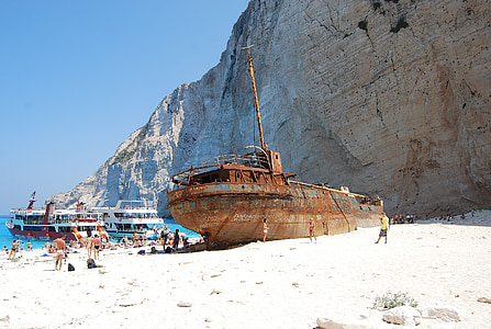 brown ship near gray rock formation thumbnail