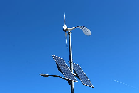white windmill with solar panels tower at daytime thumbnail