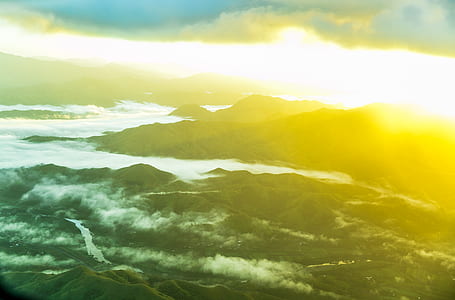 aerial photography of two divided mountains under white clouds blue skies golden hour thumbnail