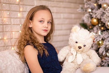 photo of girl sitting couch holding white bear plush toy thumbnail