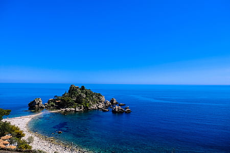 green island in the middle of body of water thumbnail