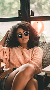 woman wearing orange sweater sitting inside room thumbnail
