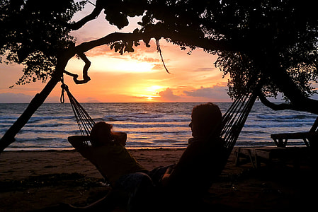 two people on hammock tied on tree thumbnail