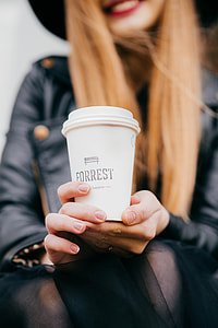 woman wearing black leather jacket holding a Forrest print cap at daytime thumbnail