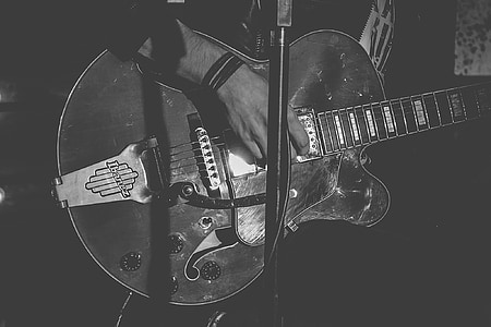 grayscale photo of person playing guitar thumbnail