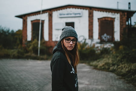 selective focus photography of woman standing near building thumbnail