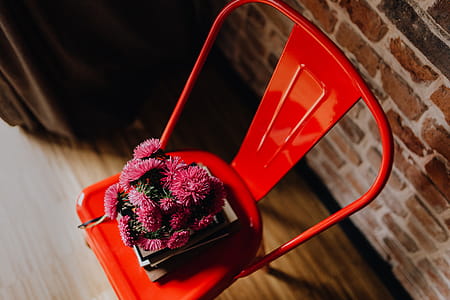 Industrial metal chair with a bouquet of pink flowers and books on it thumbnail