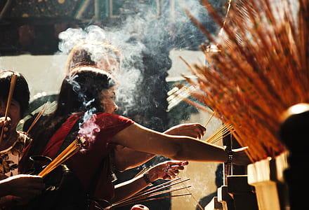 woman standing while holding scented stick thumbnail