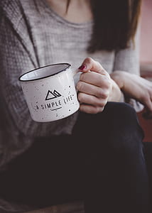 woman holding white ceramic mug thumbnail