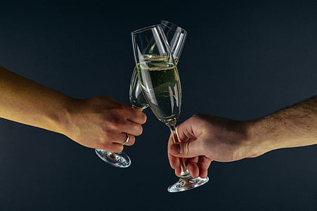 person holding two champagne flutes thumbnail