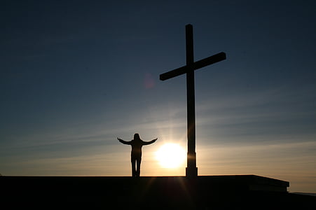 silhouette person standing beside of crucifix statute thumbnail