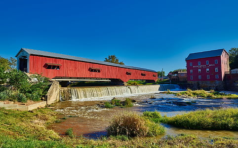 waterfalls beside red wooden building thumbnail