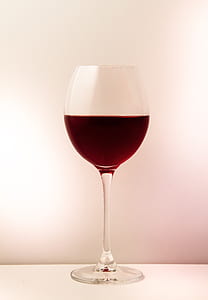 half filled wine glass on white surface thumbnail