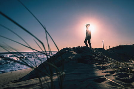 silhouette photo of person standing on seashore facing beach thumbnail