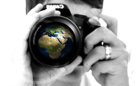 selective color photo of person using Canon DSLR camera thumbnail