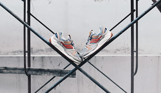 pair of gray-red-and-white running shoes on black steel scaffolding thumbnail